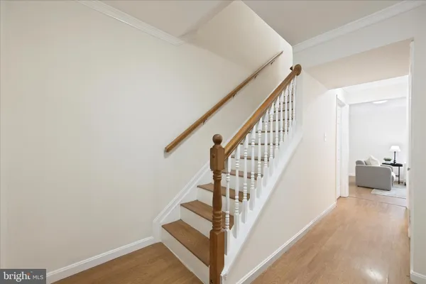 a view of a hallway with wooden floor and staircase
