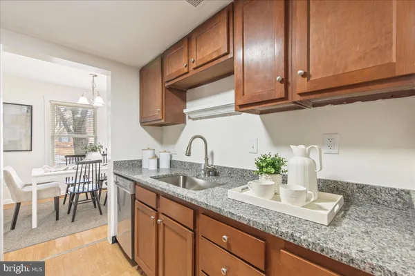 a kitchen with granite countertop stainless steel appliances a sink and cabinets