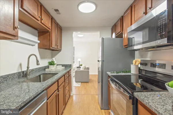 a kitchen with stainless steel appliances granite countertop a sink and cabinets