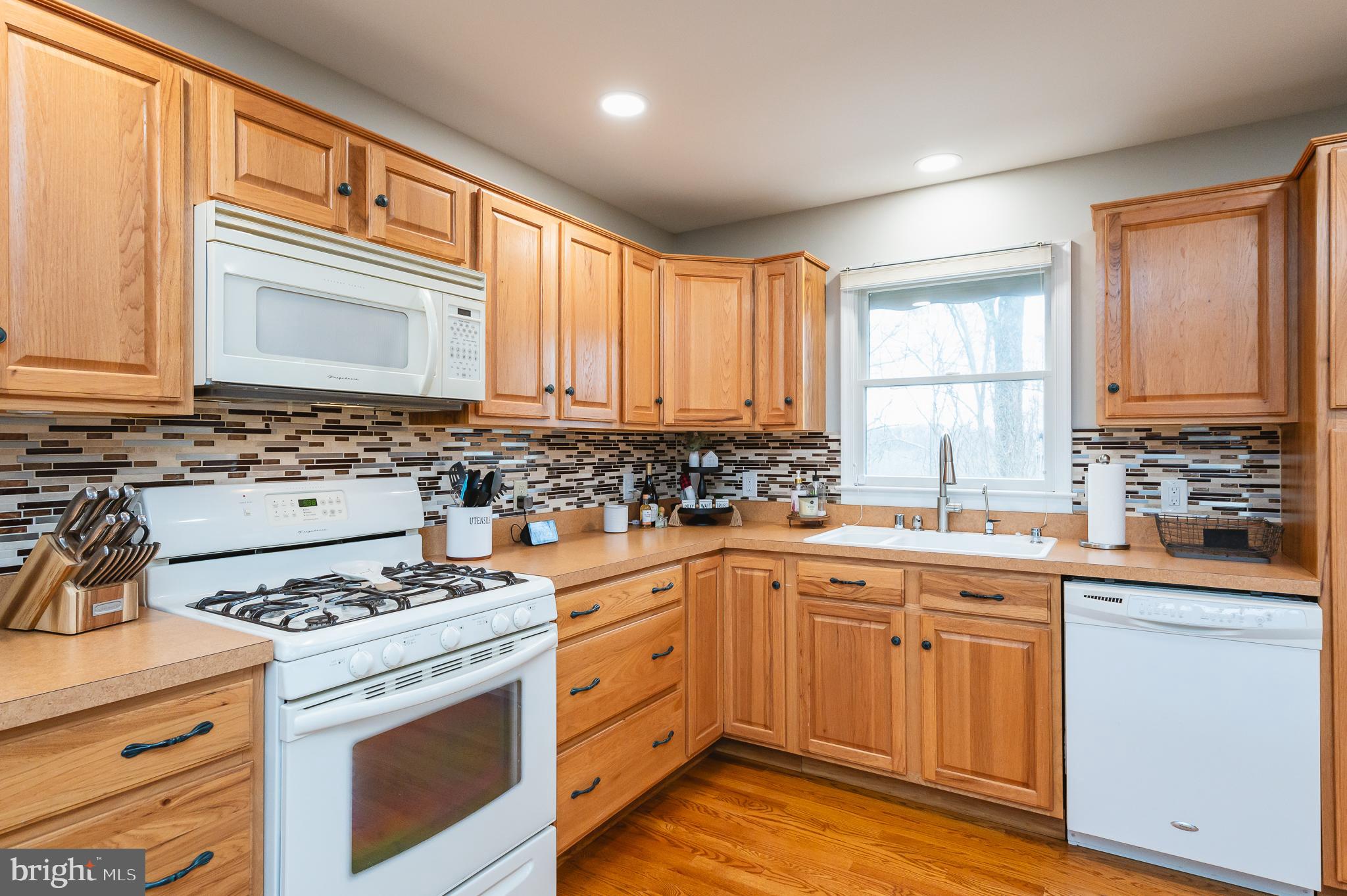 308 Cree Terrace Rising Sun, MD 21911 - Photo 19 of 51 a kitchen with a stove a sink and wooden cabinets