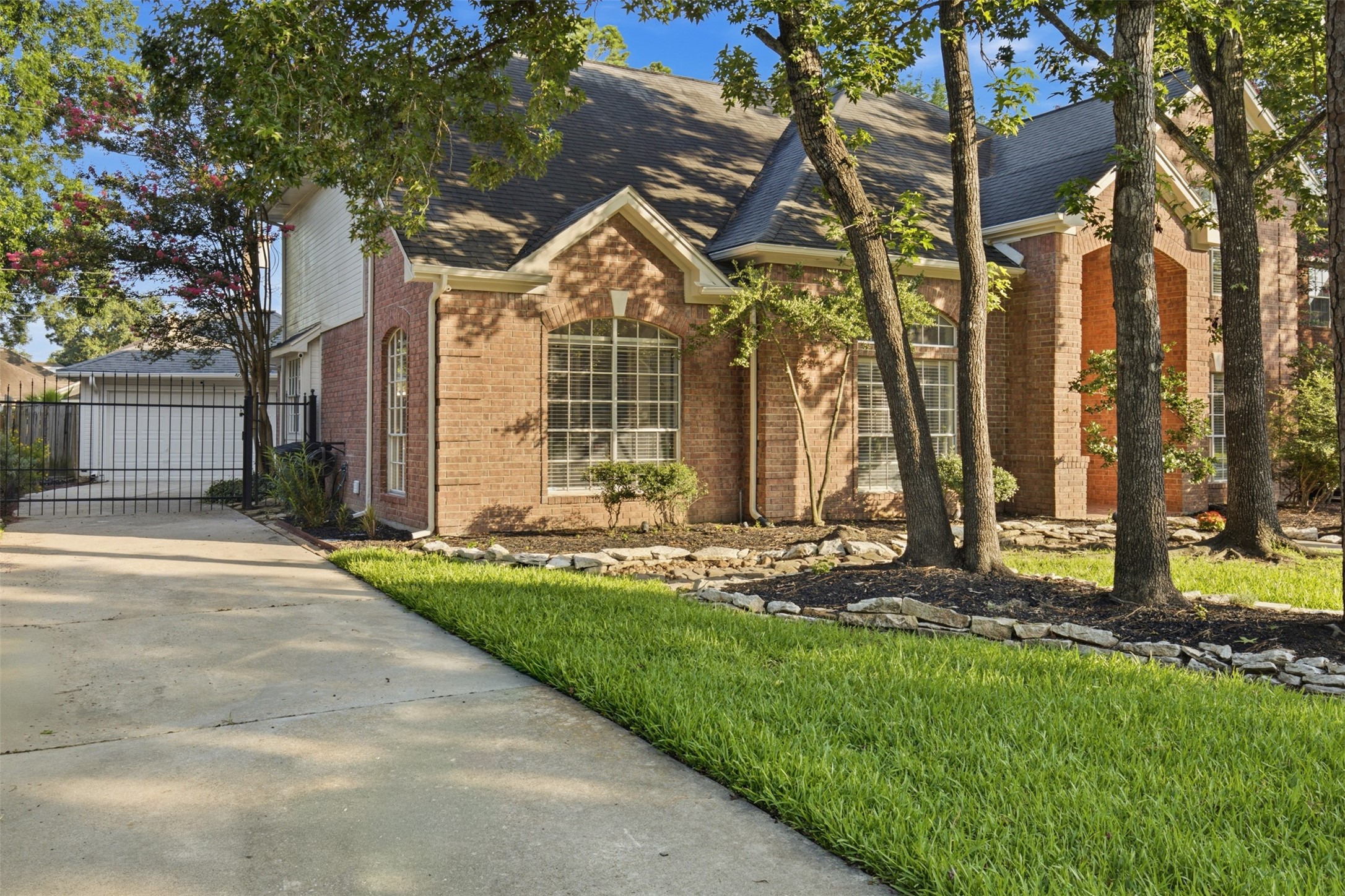 323 Magic Oaks Court Spring, TX 77388 - Photo 2 of 49 The driveway features an iron gate and leads to a two car garage.