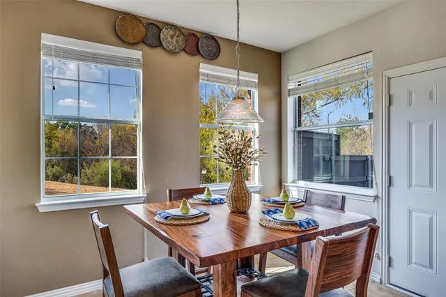 a open kitchen with stainless steel appliances granite countertop a stove a refrigerator a kitchen island a table and chairs