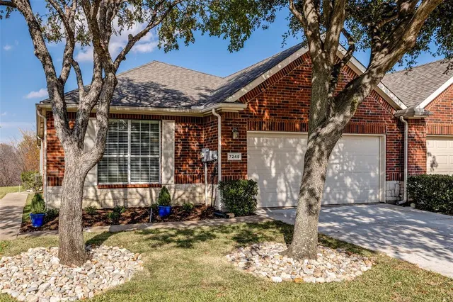 a view of a house with a tree in front of it