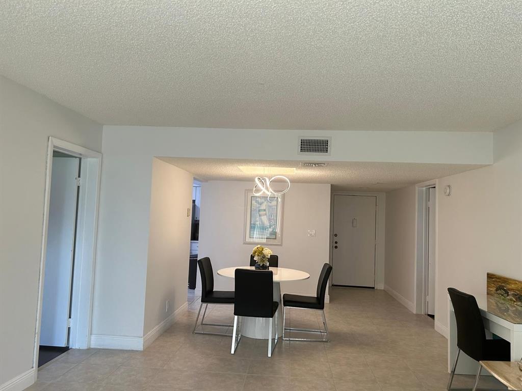 16325 Golf Club Road, Unit 109 Weston, FL 33326 - Photo 15 of 20 a view of a livingroom with a table and chairs in a room