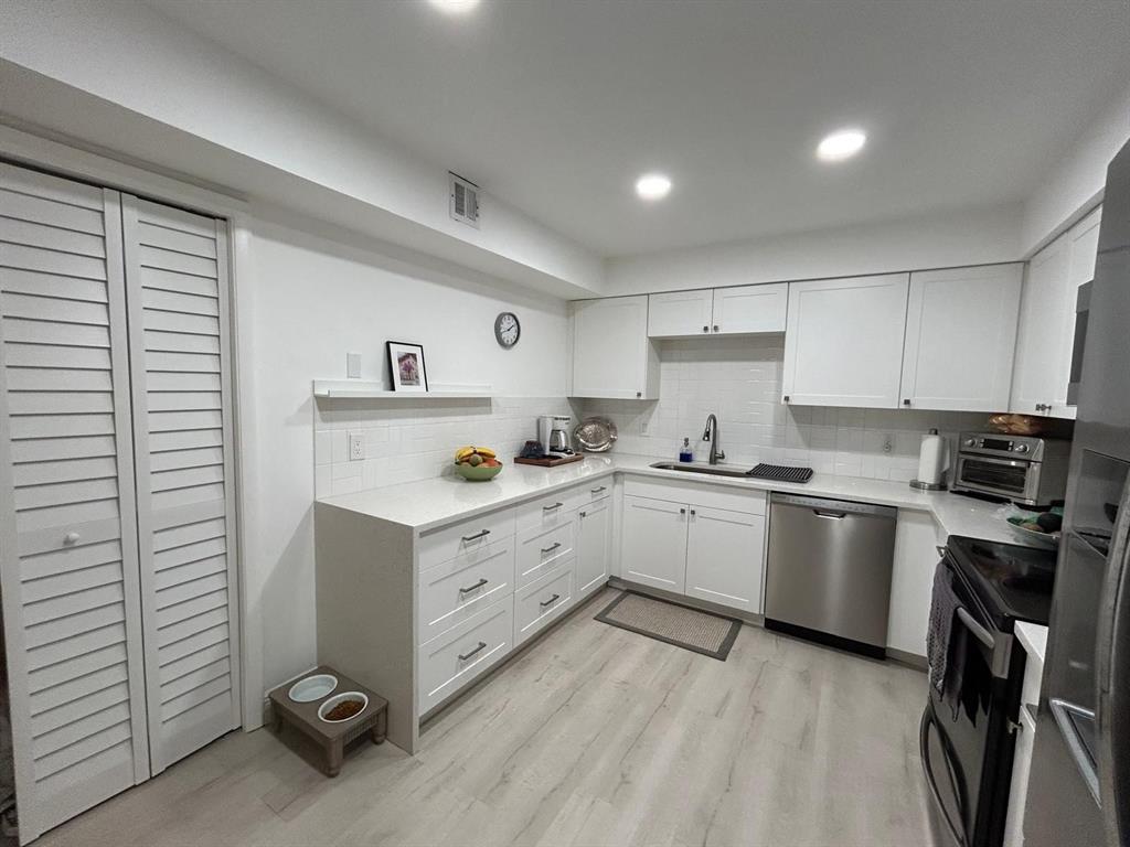 16325 Golf Club Road, Unit 109 Weston, FL 33326 - Photo 3 of 20 a kitchen with a refrigerator stove and white cabinets