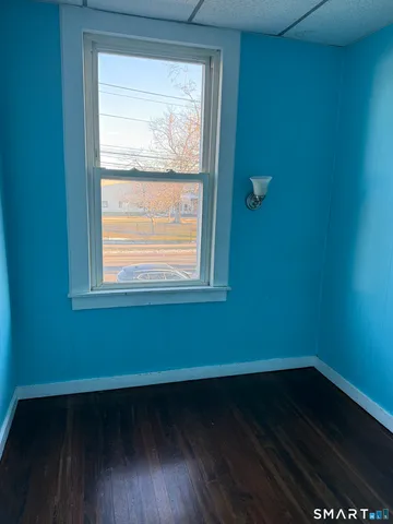 a small space with wooden floor and a window