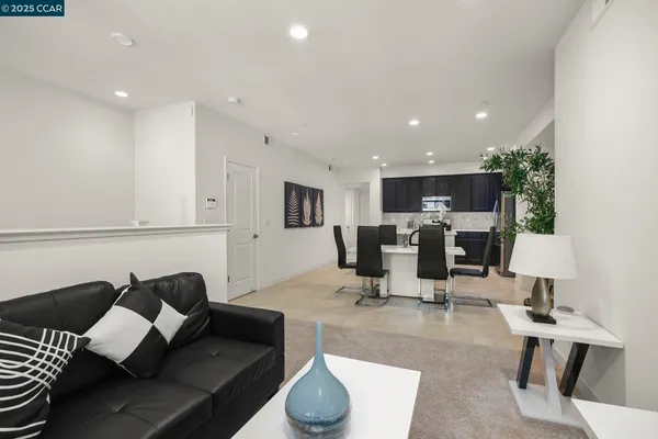 a living room with furniture and view of kitchen