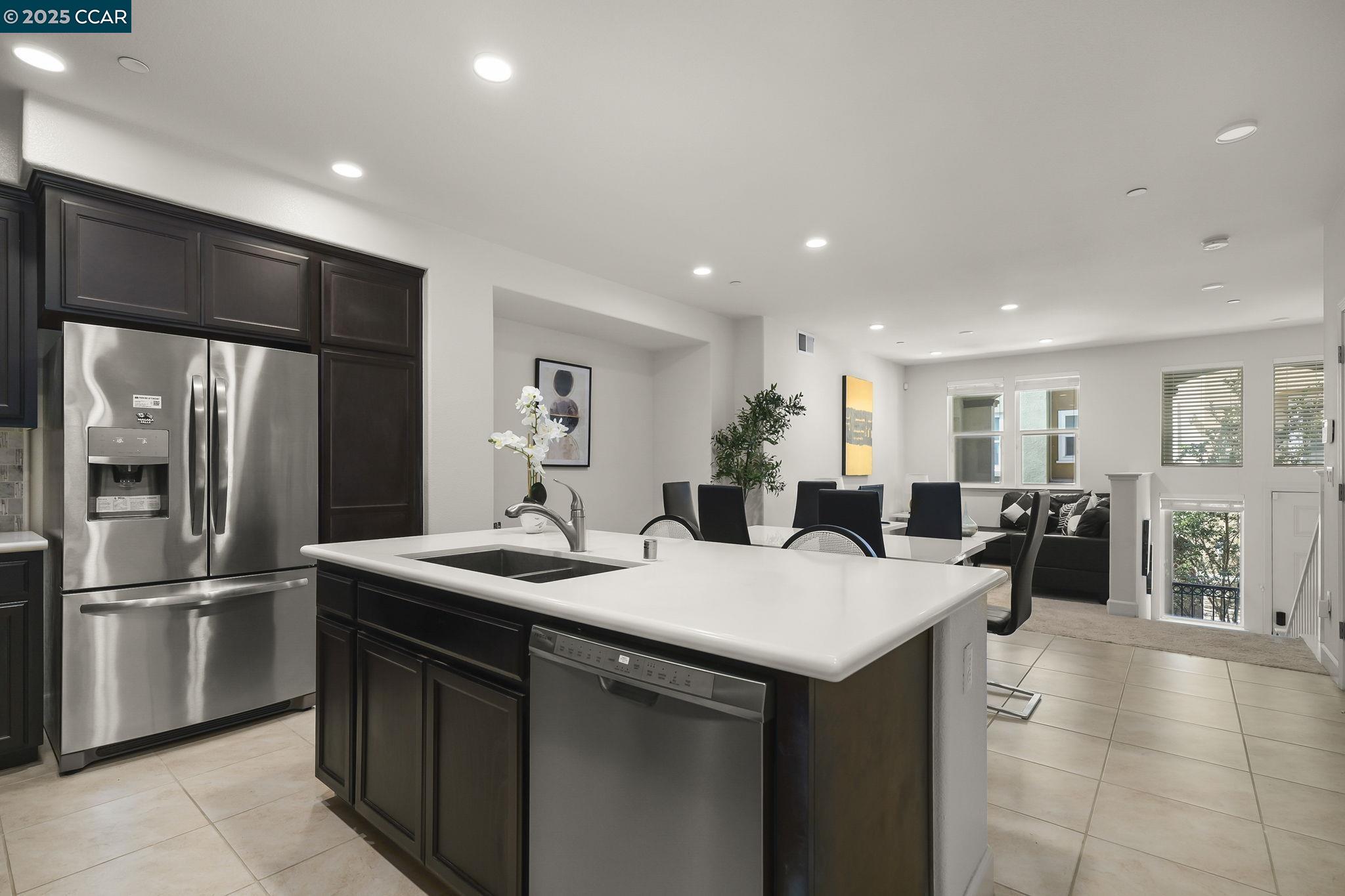 38976 Primula Terrace Newark, CA 94560 - Photo 13 of 29 a kitchen with stainless steel appliances kitchen island granite countertop a refrigerator a sink a stove and white cabinets with wooden floor