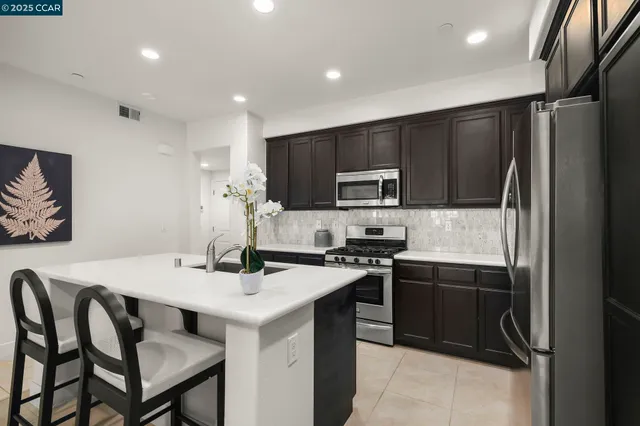 a kitchen with stainless steel appliances a microwave sink and refrigerator