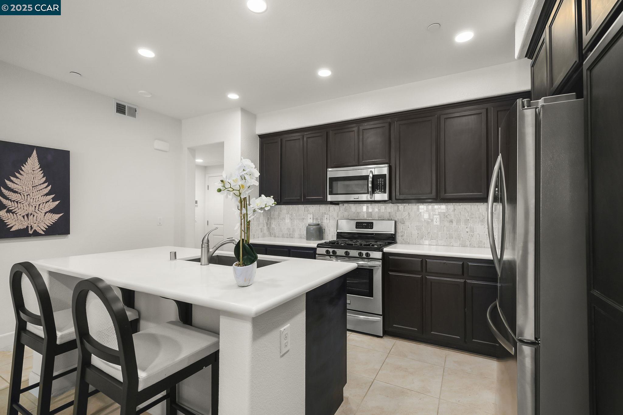 38976 Primula Terrace Newark, CA 94560 - Photo 10 of 29 a kitchen with stainless steel appliances a microwave sink and refrigerator