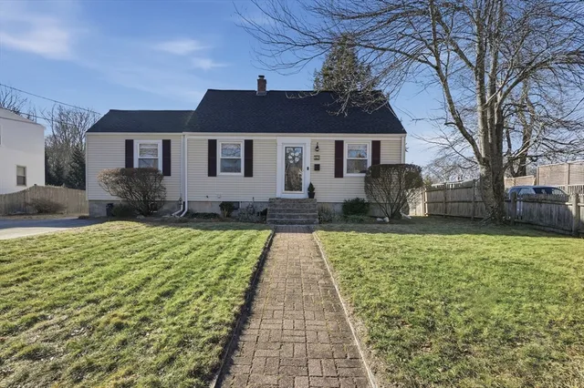 a front view of a house with a yard and potted plants