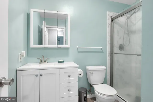 a bathroom with a toilet sink vanity and mirror