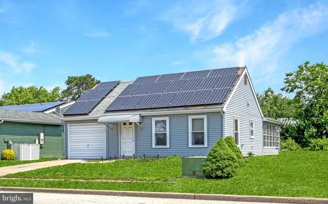 a front view of a house with a yard and potted plants