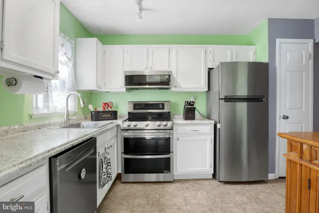 a kitchen with a stove a refrigerator and a sink