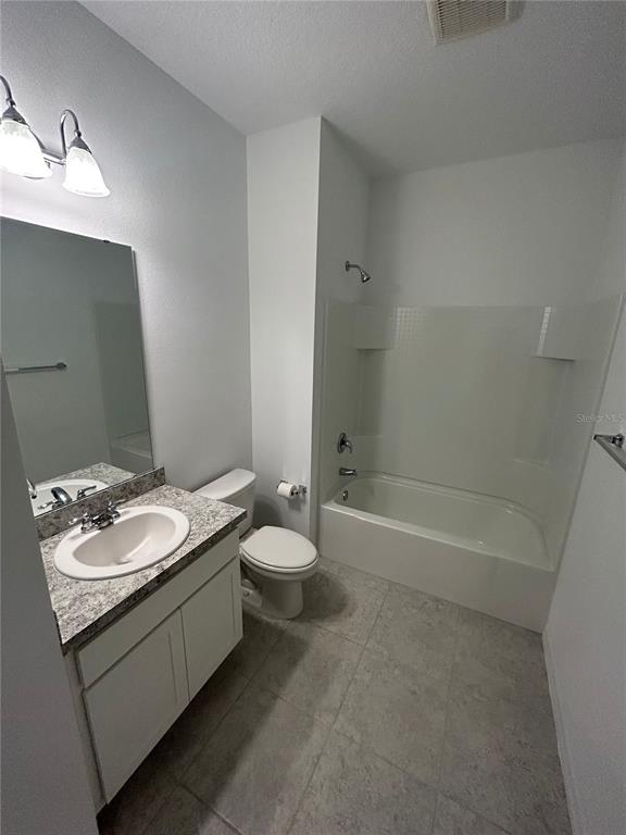 5873 Beefmaster Road St. Cloud, FL 34771 - Photo 8 of 16 a bathroom with a granite countertop sink a toilet and bathtub