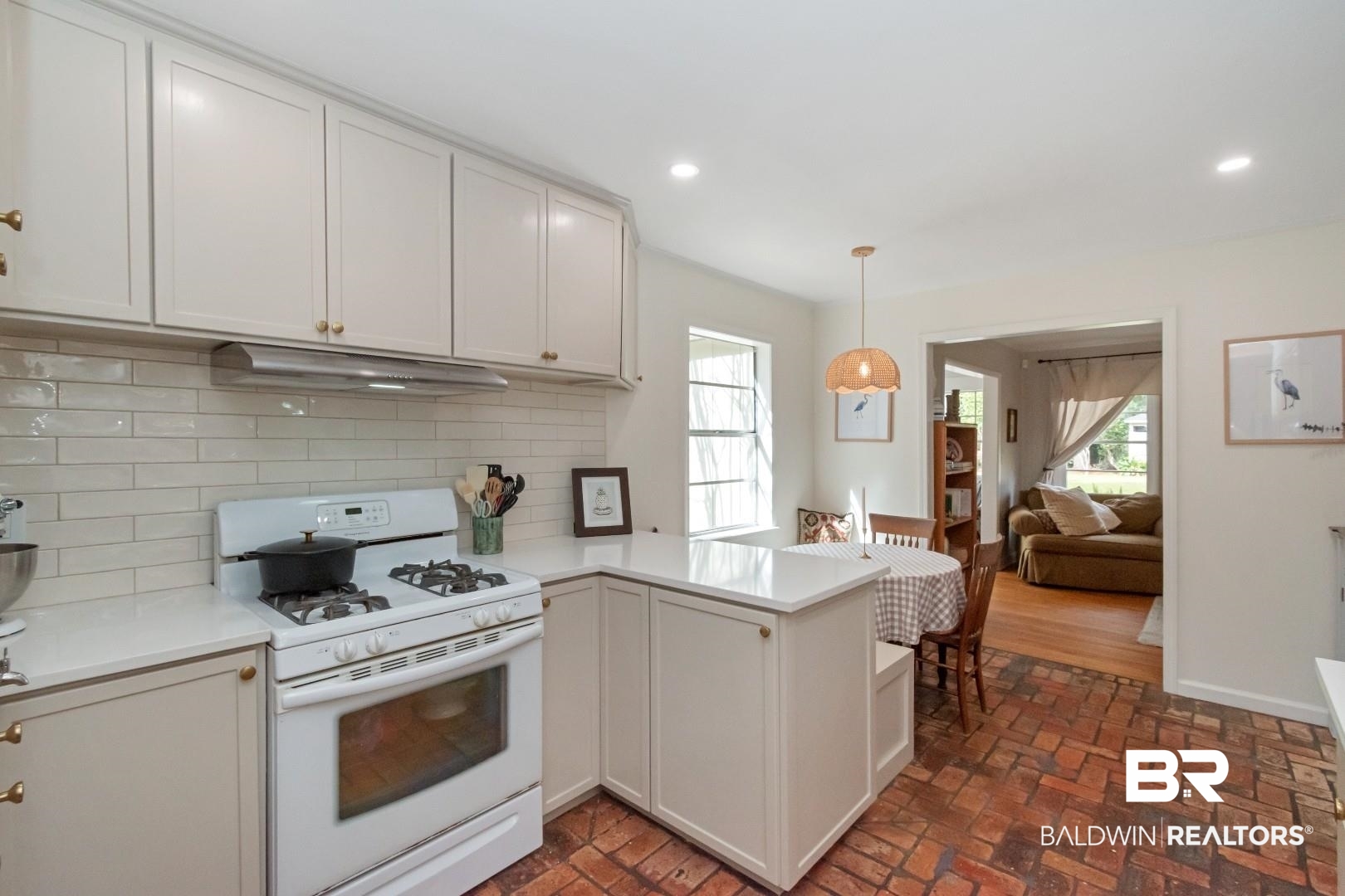 113 Ellinor Street Mobile, AL 36606 - Photo 12 of 28 Kitchen with a peninsula, white gas stove, decorative backsplash, light countertops, and under cabinet range hood
