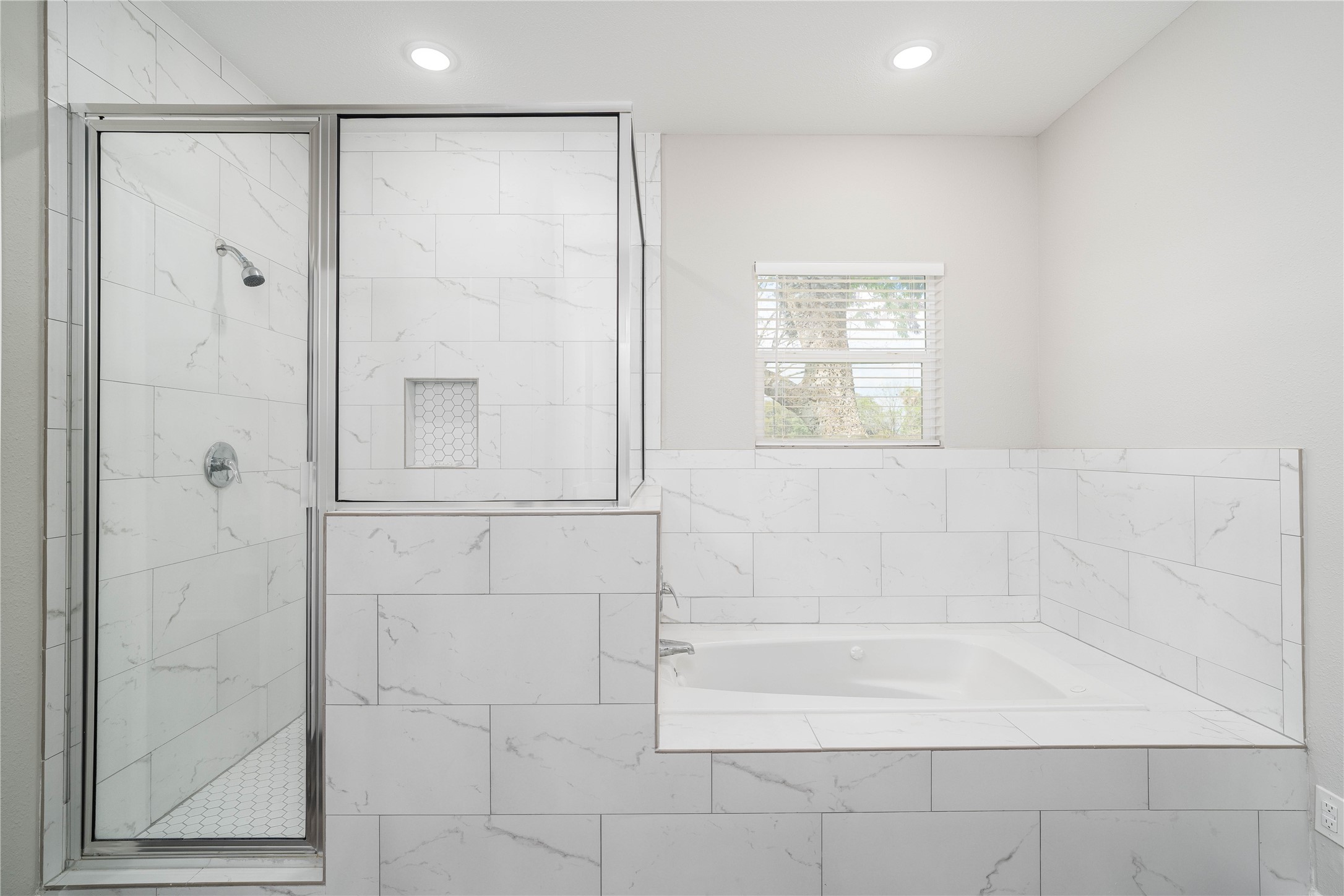 231 McCormick Street Columbus, TX 78934 - Photo 16 of 27 Primary Bathroom – Luxurious soaking tub and separate glass-enclosed shower, complemented by elegant tile work throughout.
