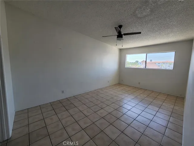 an empty room with windows and ceiling fan