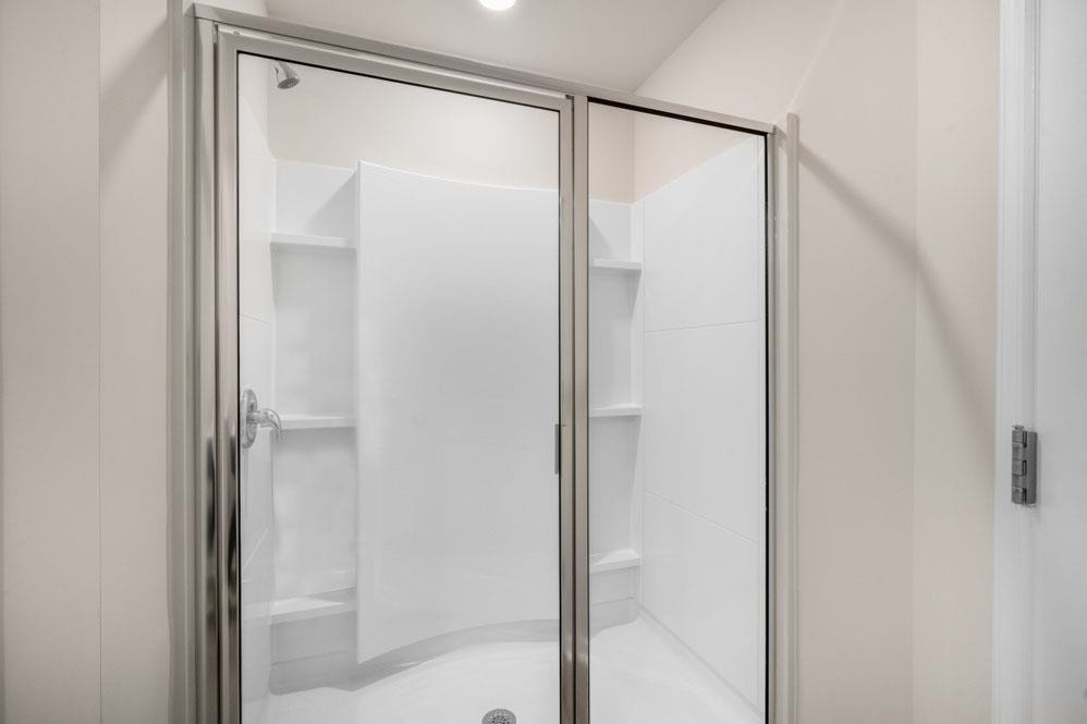 115 Starlight Street Sanford, NC 27330 - Photo 21 of 37 a bathroom with a glass shower door