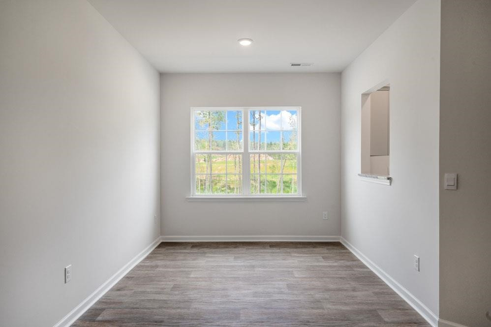 115 Starlight Street Sanford, NC 27330 - Photo 9 of 37 an empty room with wooden floor and windows