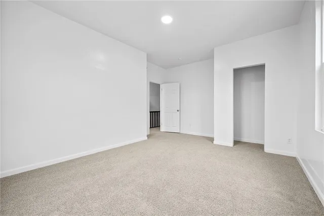 an empty room with an entryway and closet