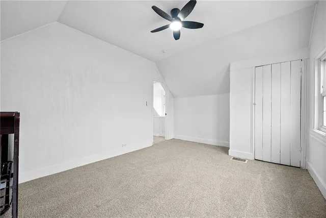 an empty room with a ceiling fan and a window