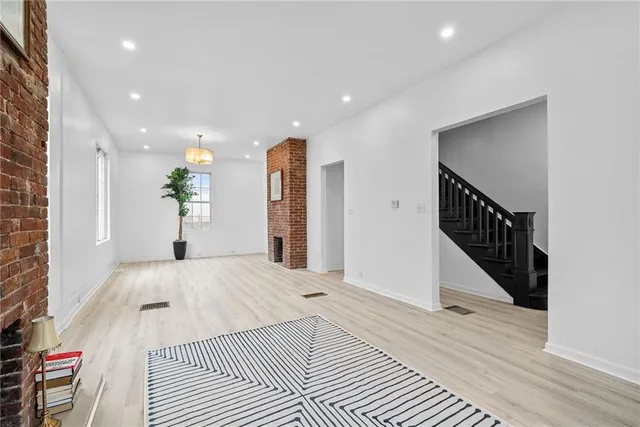 a view of a bedroom with wooden floor and stairs