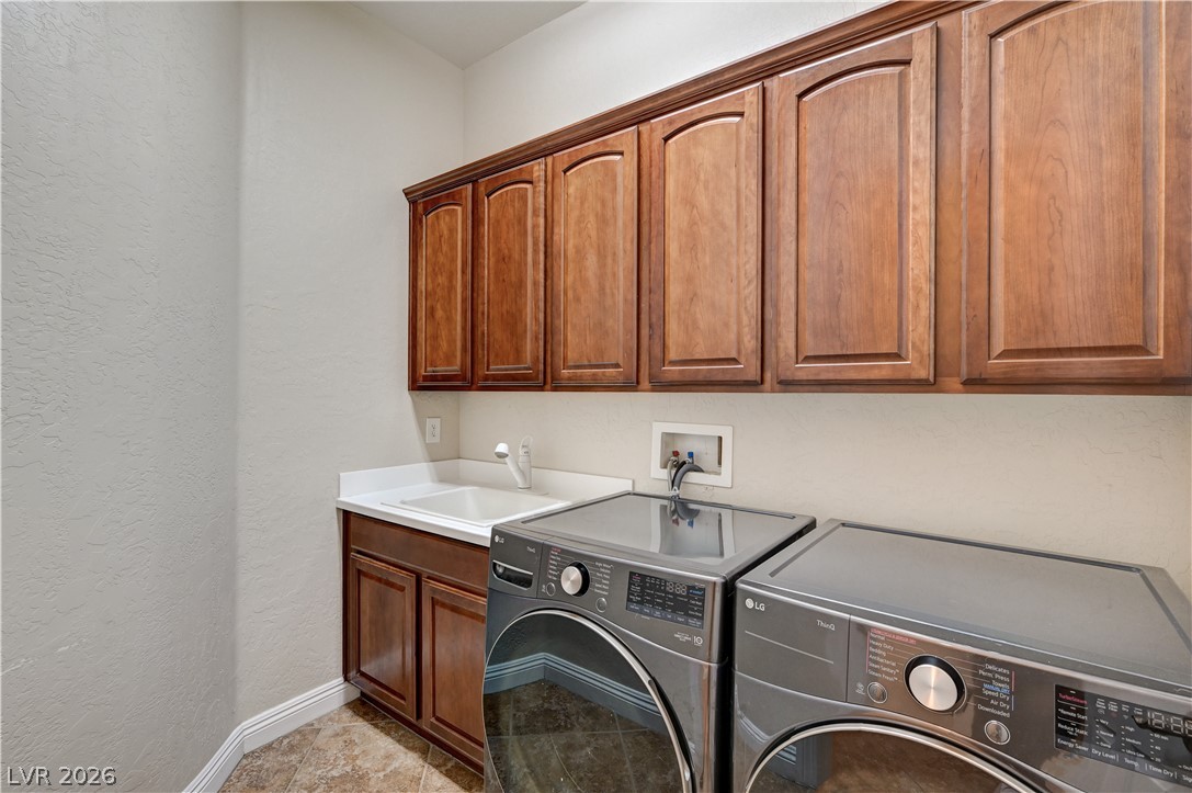 2793 Rosenhearty Drive Henderson, NV 89044 - Photo 32 of 77 Functional laundry space featuring durable tile flooring and rich wood cabinetry.