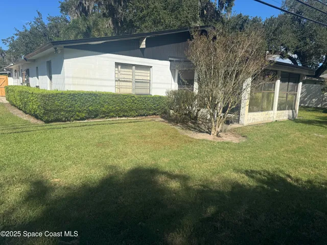 a view of a house with backyard and tree