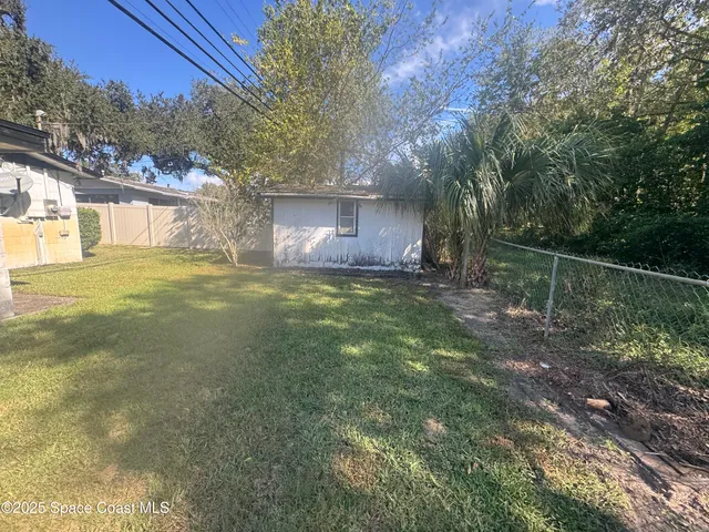 a view of a yard with a house in the background