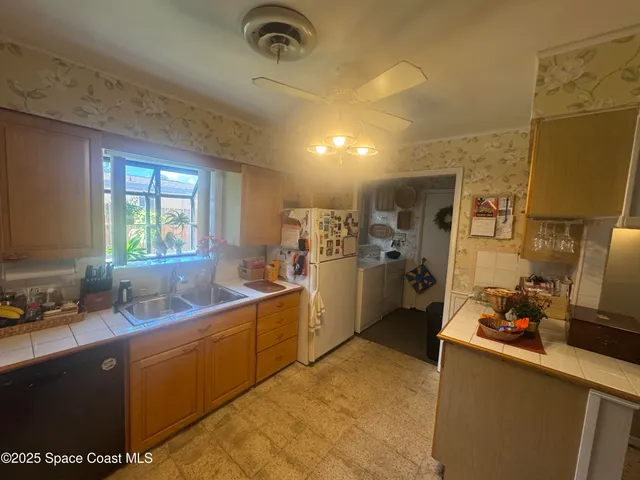 a kitchen with sink a refrigerator and cabinets