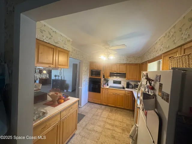 a view of a kitchen with furniture and a refrigerator