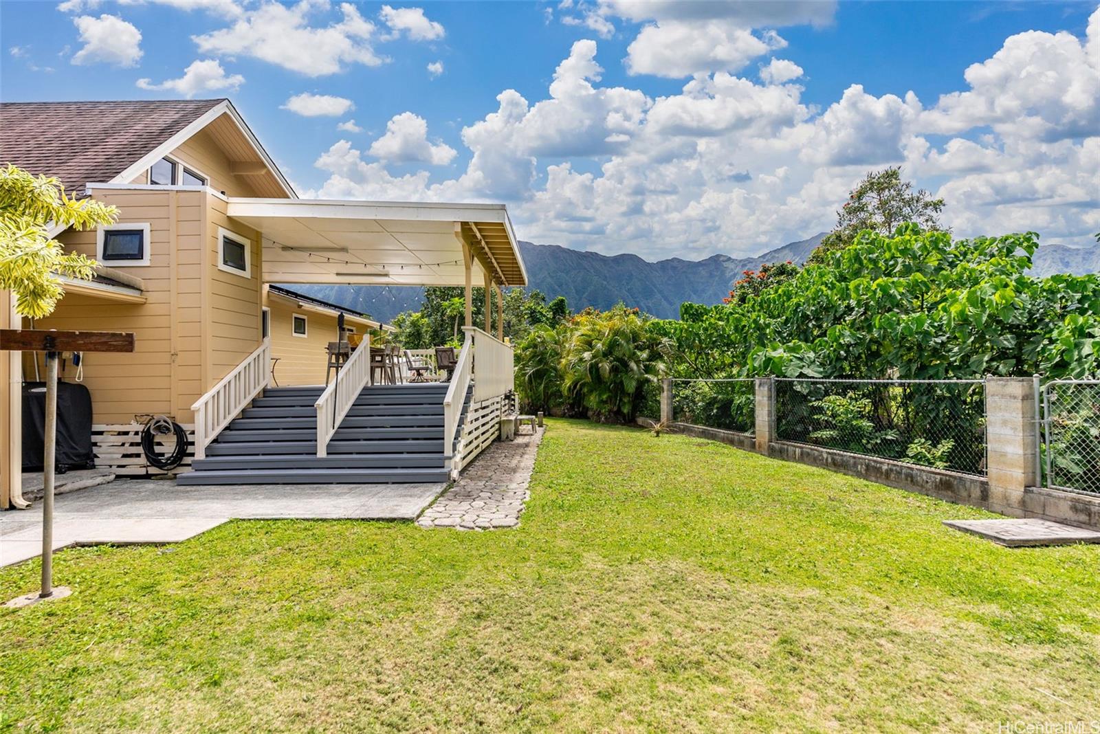 a view of a backyard with plants and wooden fence