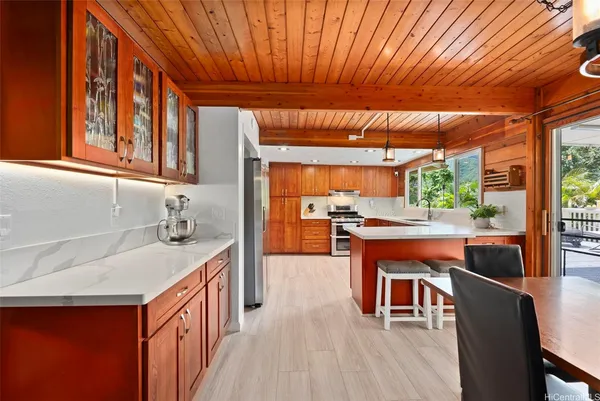 a kitchen with stainless steel appliances granite countertop a sink a stove and a wooden floors
