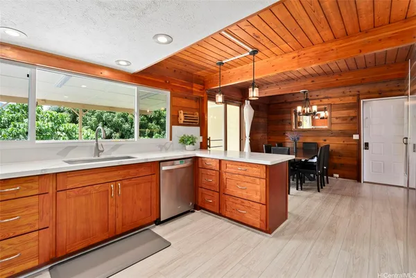 a kitchen with stainless steel appliances granite countertop a sink and wooden cabinets
