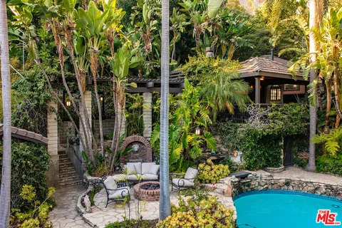 a view of swimming pool with lounge chair and trees