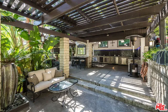 a view of a yard with plants and large trees