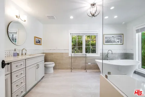 a spacious bathroom with a granite countertop sink mirror and bathtub