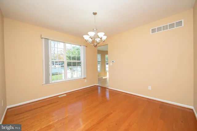 a view of wooden floor and a chandelier in a room