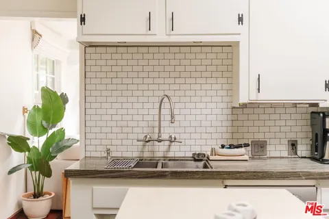 a bathroom with a sink a vanity and a potted plant
