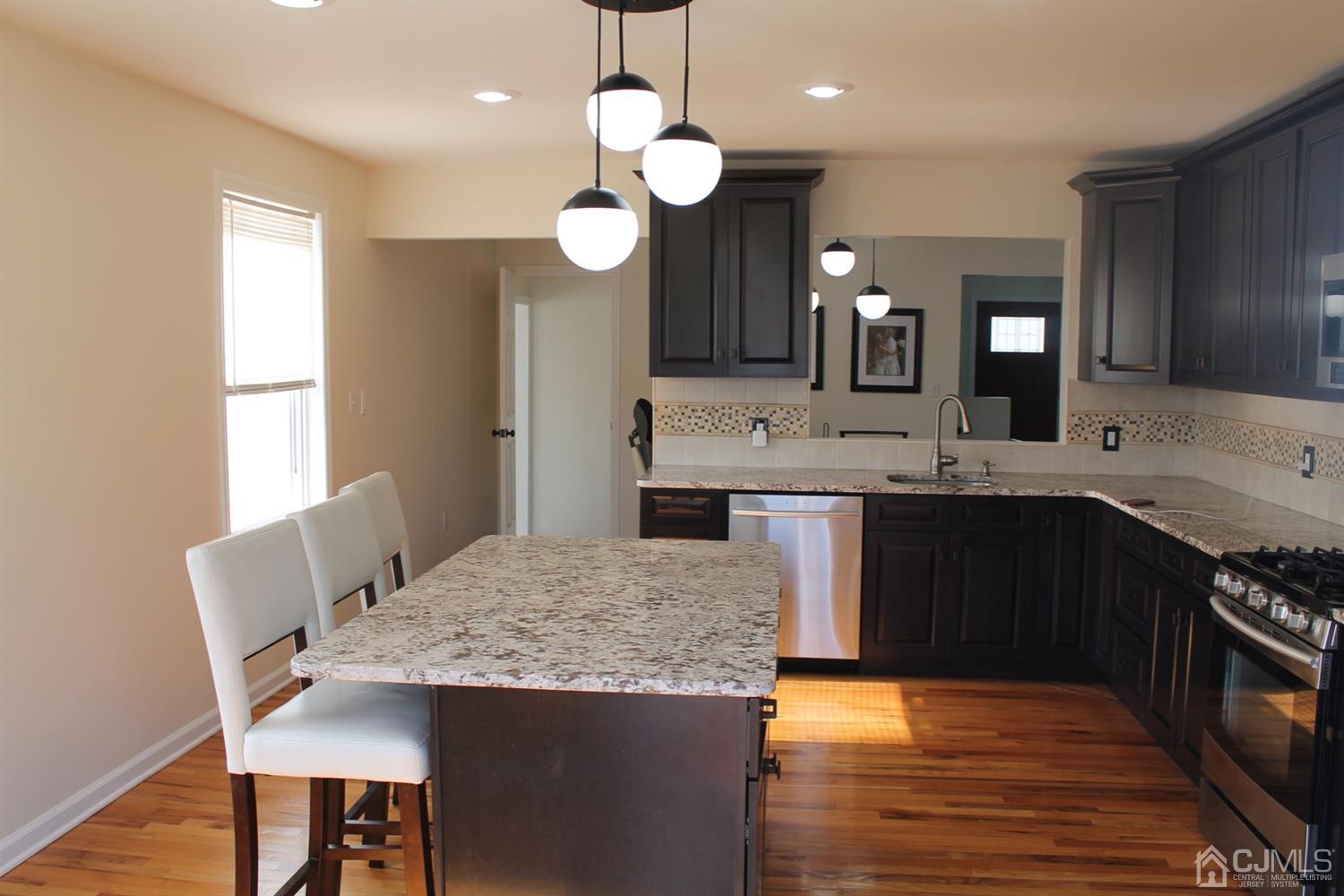 29 Longfield Road New Brunswick, NJ 08901 - Photo 10 of 25 a kitchen with a sink and a stove top oven with wooden floor