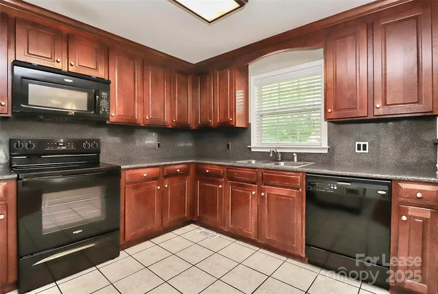 a kitchen with granite countertop wooden cabinets stainless steel appliances and a window