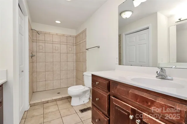 a bathroom with a granite countertop sink a toilet and a mirror