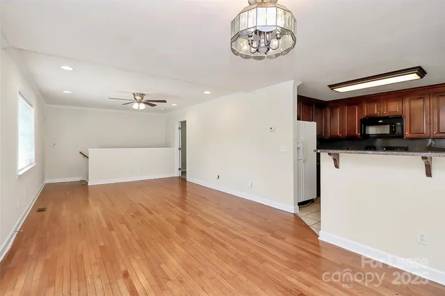 a view of a room with wooden floor and a kitchen view