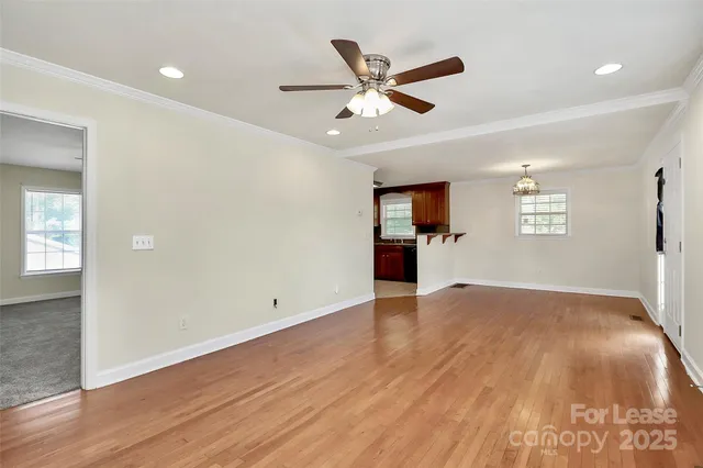a view of empty room with wooden floor and window