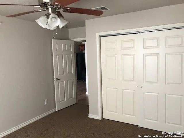 an empty room with a chandelier fan