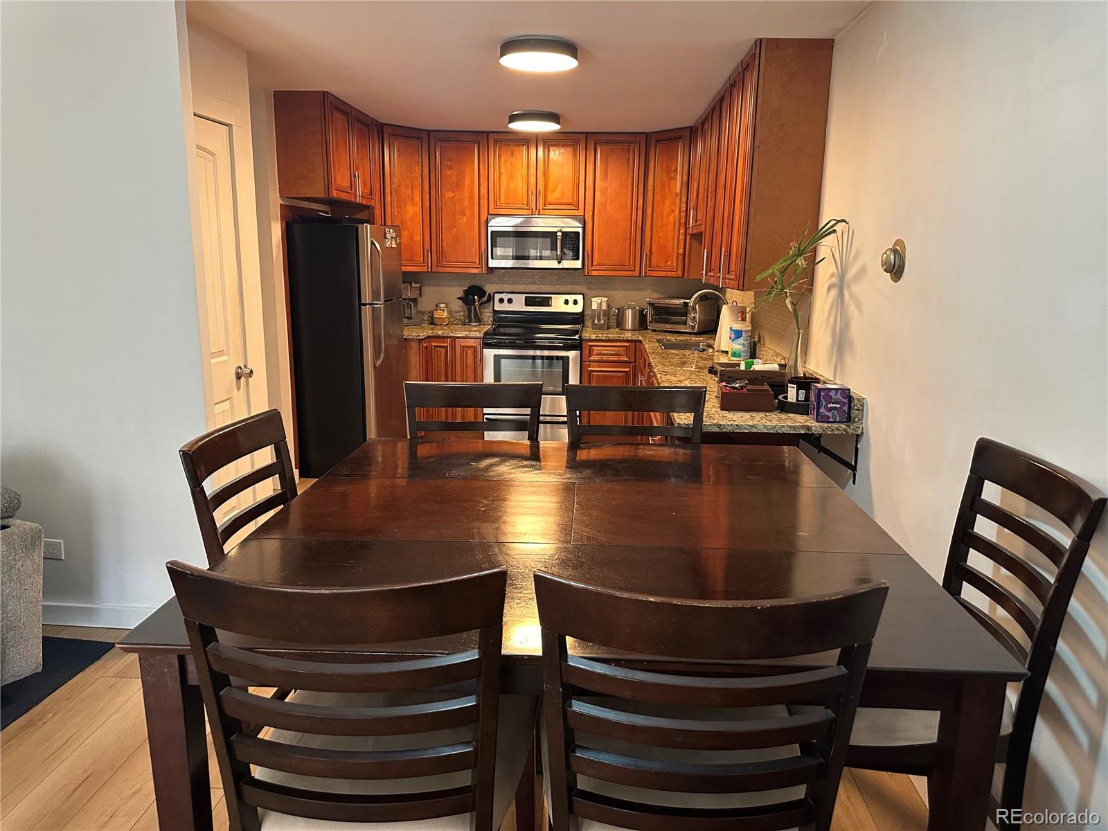 615 South Clinton Street, Unit 9B Denver, CO 80247 - Photo 4 of 24 a kitchen with kitchen island a stove and a refrigerator