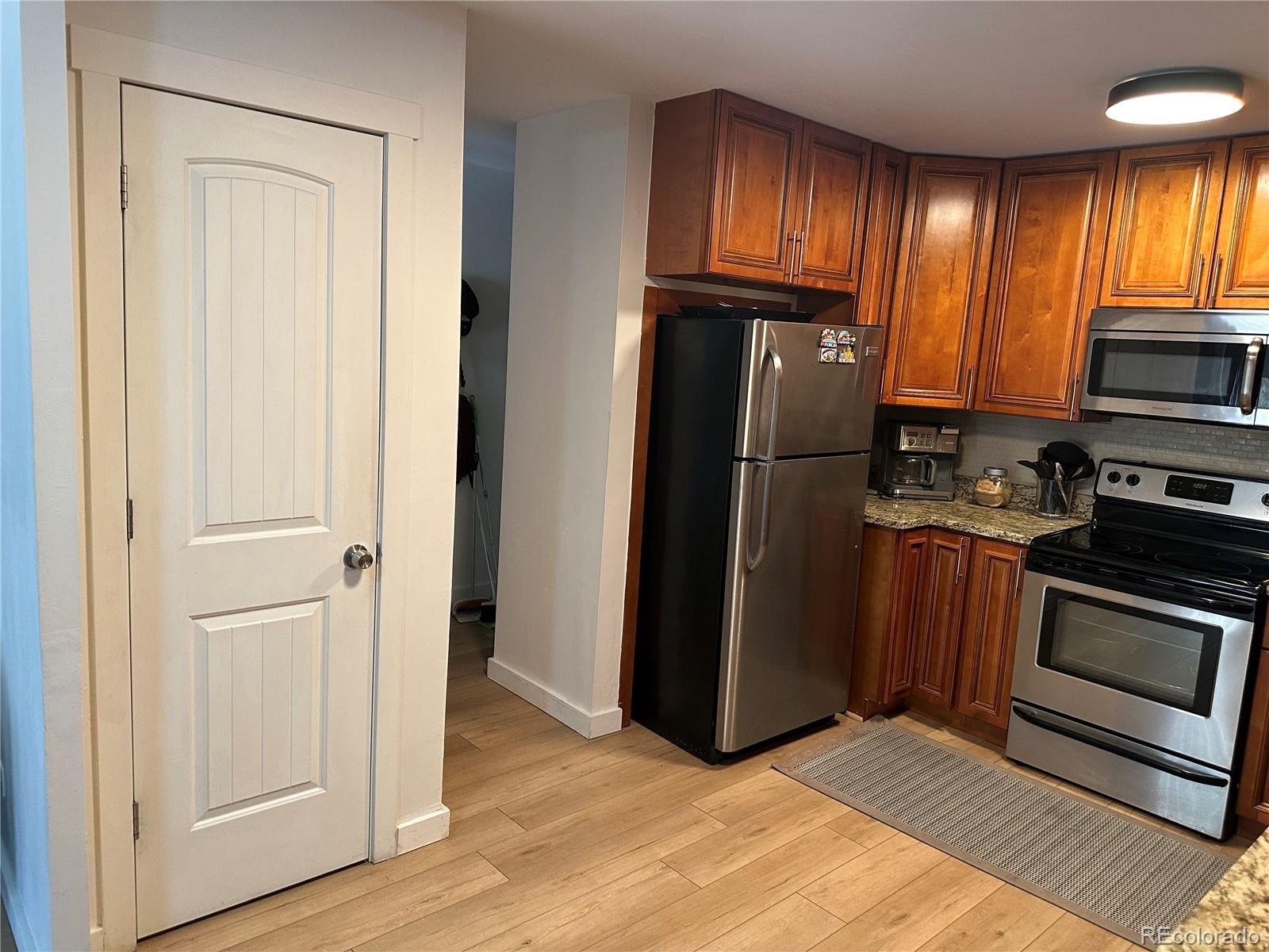 615 South Clinton Street, Unit 9B Denver, CO 80247 - Photo 6 of 24 a kitchen with granite countertop stainless steel appliances a refrigerator and a sink