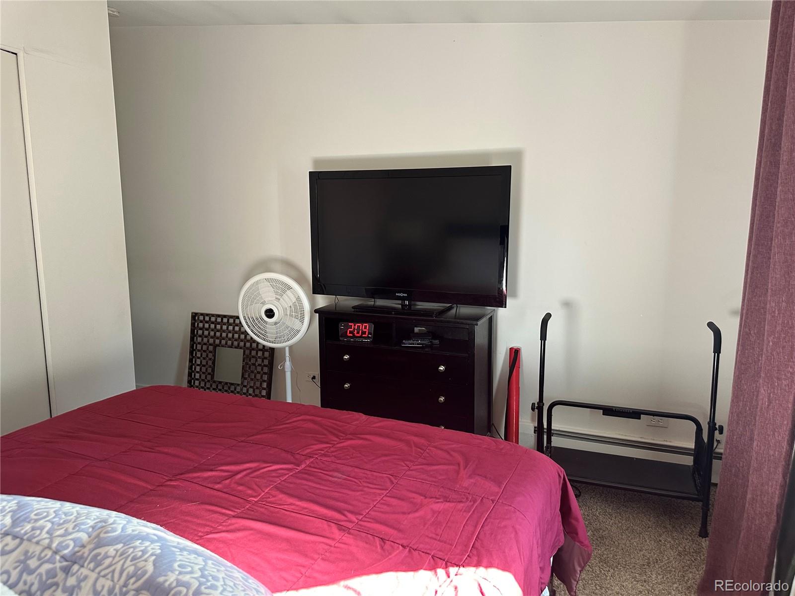 615 South Clinton Street, Unit 9B Denver, CO 80247 - Photo 10 of 24 a bedroom with a bed and a flat screen tv