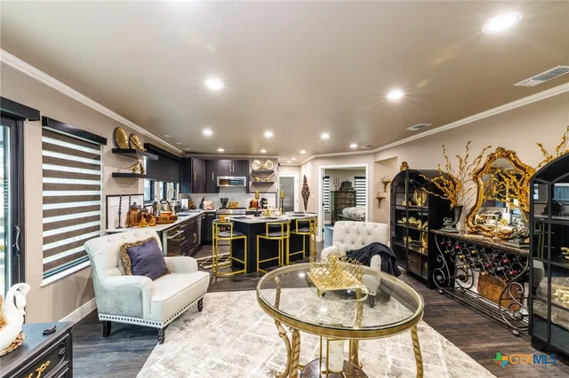 a living room with furniture a rug and kitchen view
